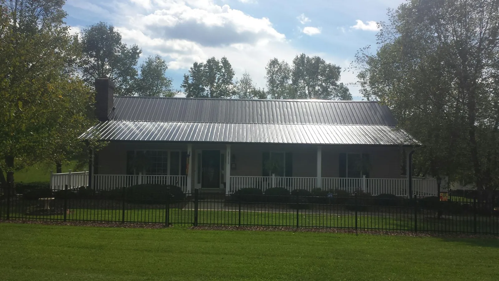 Gray metal roof on a brick ranch with a full width front porch — Gutter Guard Installation work by our crew in Chicago