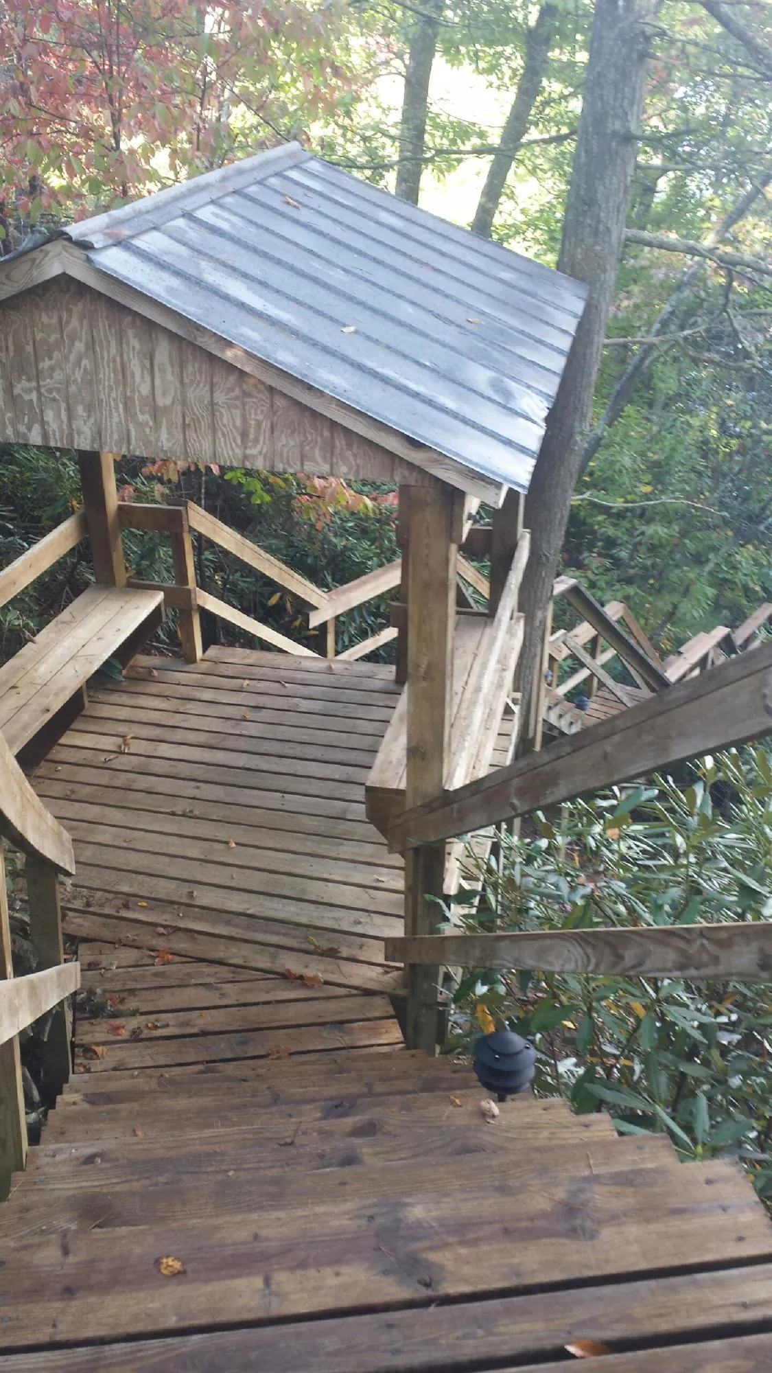 Metal roofed shelter over wooden steps on a wooded walkway — Skylight Repair & Installation work by our crew in Chicago