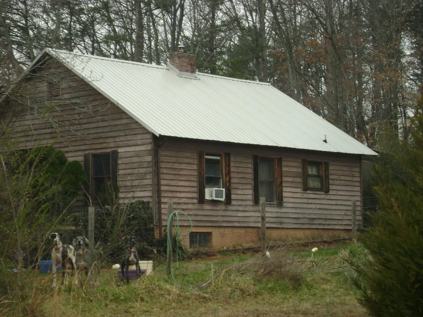 White metal roof on an old wood sided farmhouse, from a Metal Roof Installation job in Chicago
